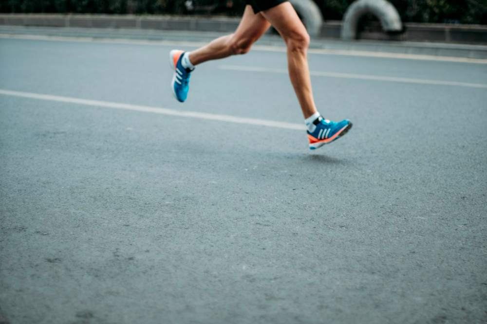 Runner on asphalt, legs close-up